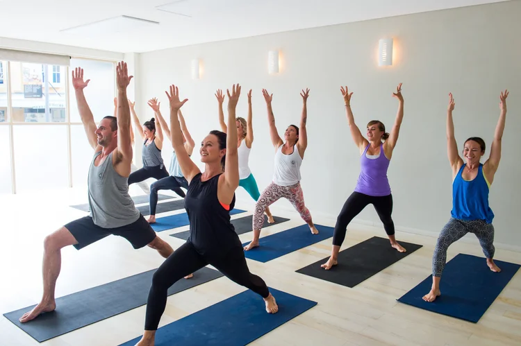 Yoga class holding a warrior pose at This Is Yoga Randwick